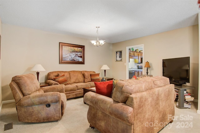 living room featuring an inviting chandelier, a textured ceiling, and light carpet