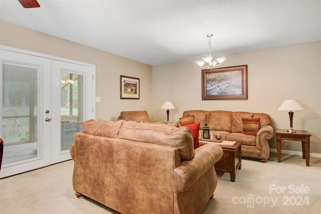 carpeted living room with ceiling fan with notable chandelier and french doors