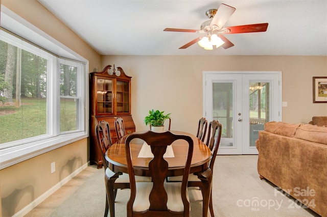 carpeted dining area with french doors, ceiling fan, and a healthy amount of sunlight