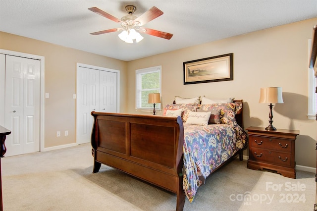 carpeted bedroom featuring ceiling fan and a textured ceiling