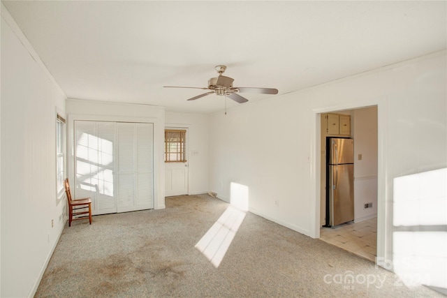 spare room with ceiling fan, light colored carpet, and ornamental molding