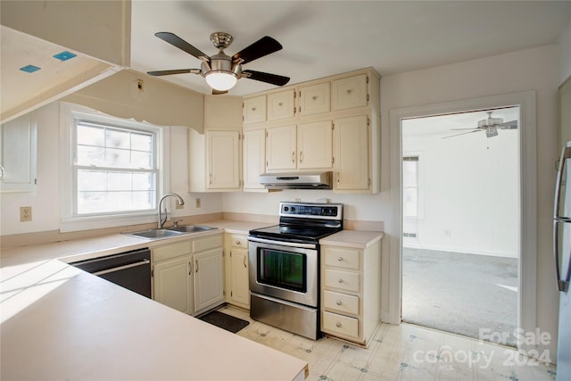 kitchen featuring cream cabinets, sink, ceiling fan, appliances with stainless steel finishes, and light colored carpet