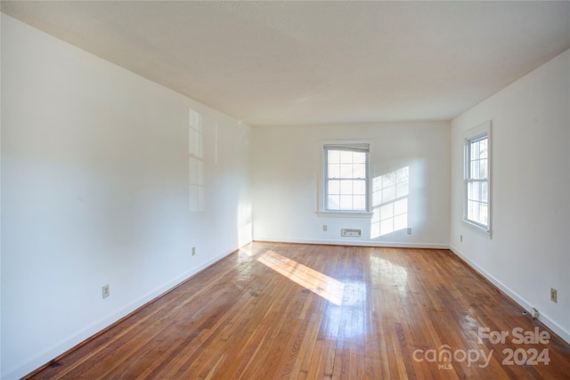 unfurnished room featuring hardwood / wood-style flooring and plenty of natural light