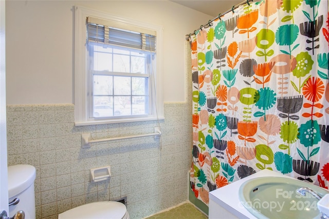 bathroom featuring vanity, tile walls, and toilet