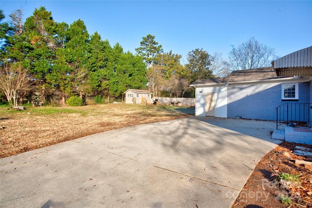 view of side of home featuring a yard, a shed, and a patio area