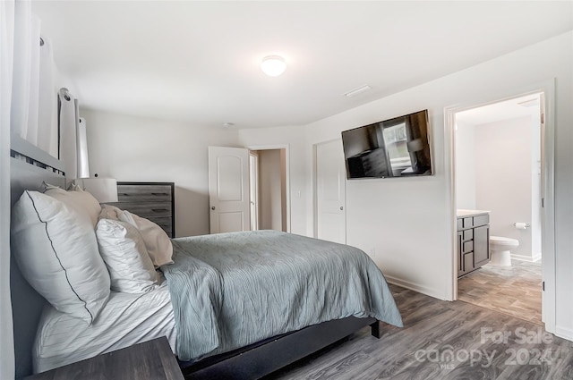 bedroom featuring connected bathroom and hardwood / wood-style floors