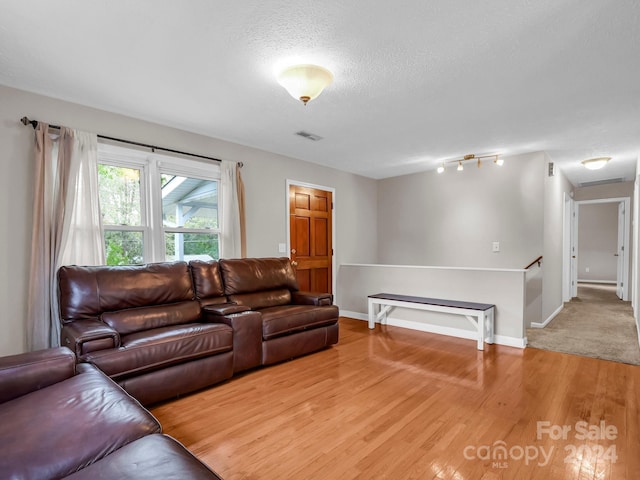 living room with a textured ceiling and hardwood / wood-style floors