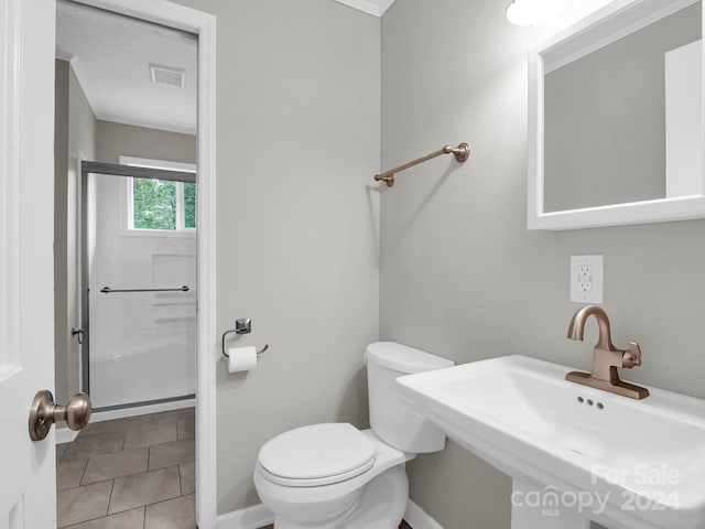 bathroom with sink, toilet, a shower with shower door, and tile patterned flooring