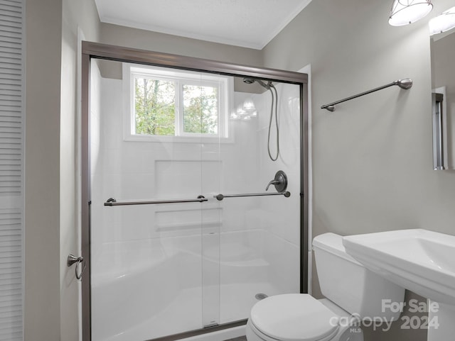 bathroom featuring a textured ceiling, toilet, and walk in shower