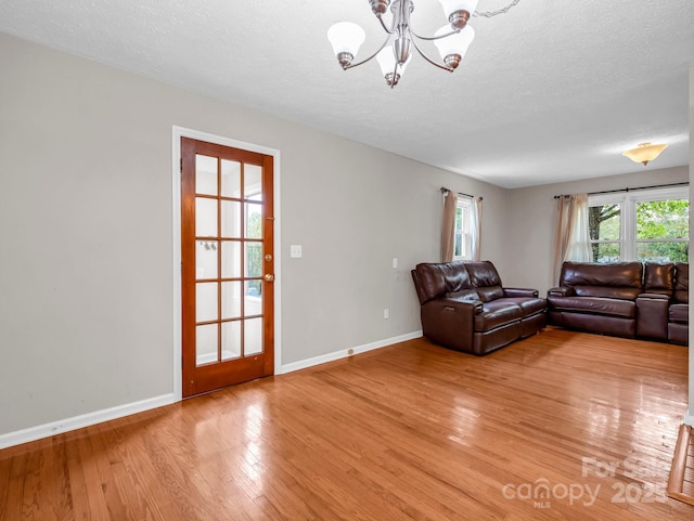 200 Frost Rd, Saluda, NC 28773 - living area with a chandelier, light wood-style floors, baseboards, and a textured ceiling