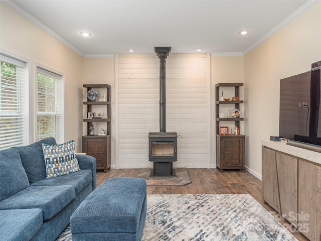 living room featuring ornamental molding, light wood-type flooring, and a wood stove