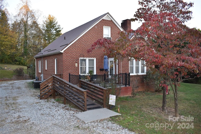 view of front of property with a wooden deck and a front lawn