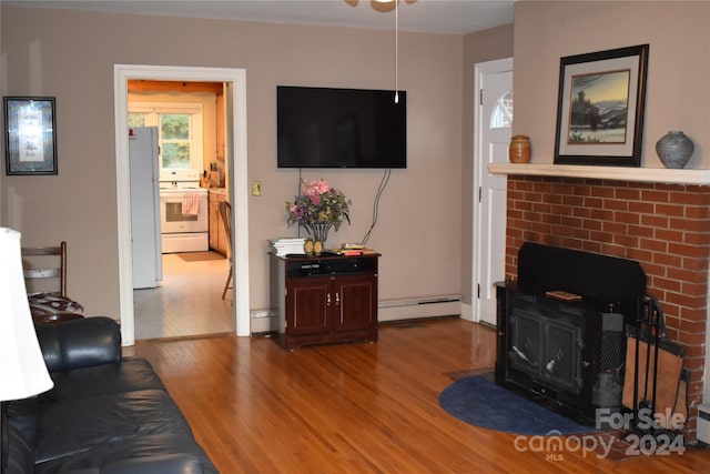 living room with a baseboard heating unit and wood-type flooring