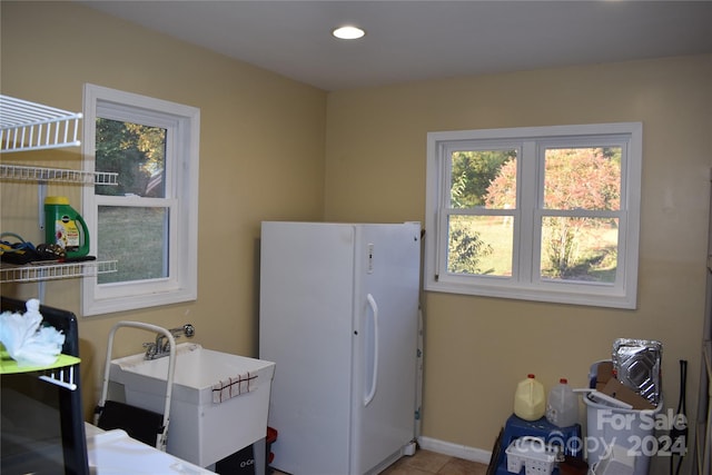 laundry room featuring sink and light tile patterned flooring