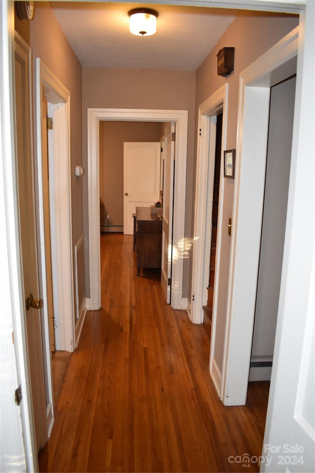 corridor with hardwood / wood-style floors