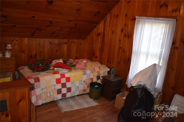 bedroom with lofted ceiling, wooden walls, wood-type flooring, and wood ceiling