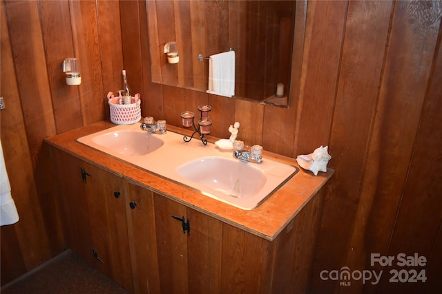 bathroom featuring vanity and wood walls