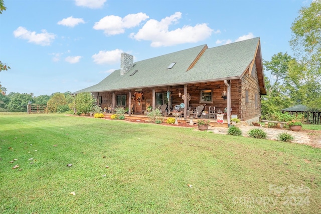 back of property with a lawn and a patio area