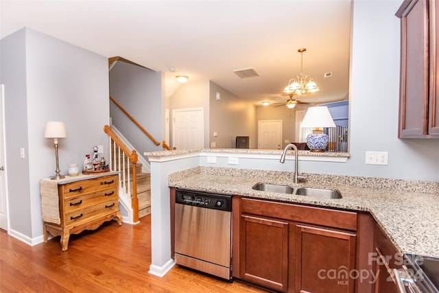 kitchen featuring hanging light fixtures, sink, kitchen peninsula, stainless steel dishwasher, and light wood-type flooring