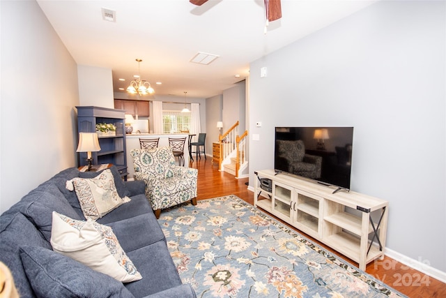 living room featuring wood-type flooring and ceiling fan with notable chandelier