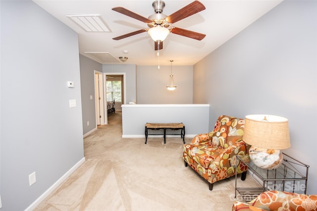 living area with ceiling fan and light colored carpet