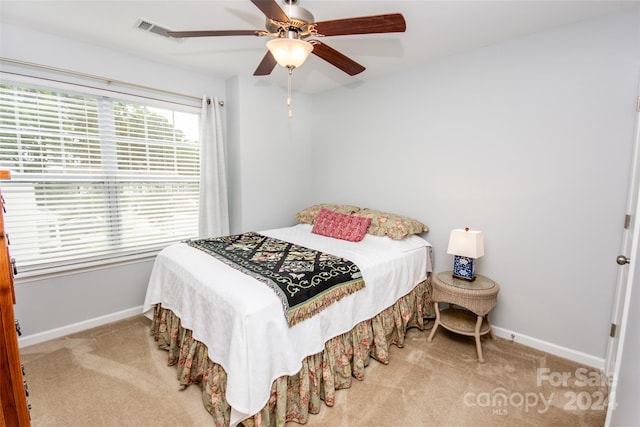 bedroom with light carpet and ceiling fan