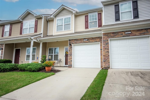 view of property featuring a garage and a front yard