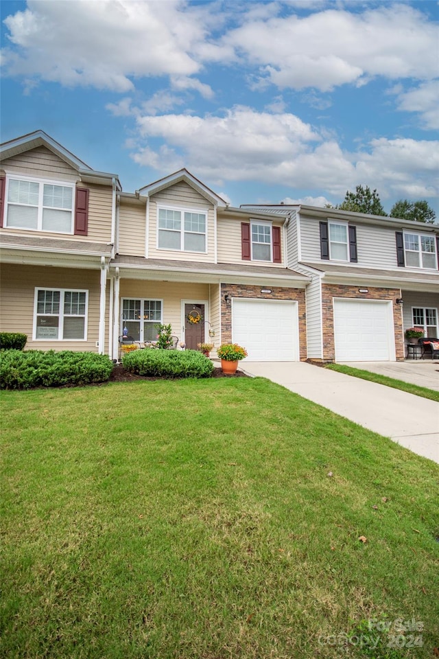 view of property featuring a front yard and a garage