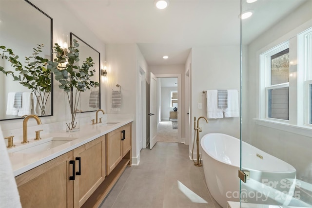 bathroom featuring tile patterned flooring, vanity, and a tub