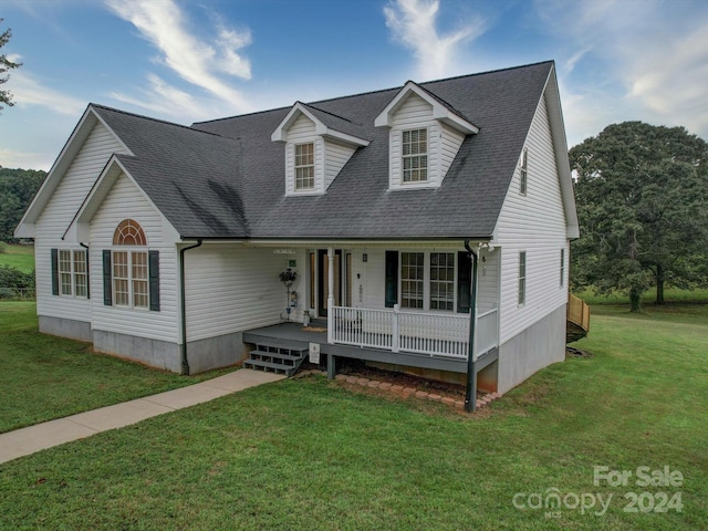 cape cod house with covered porch and a front yard