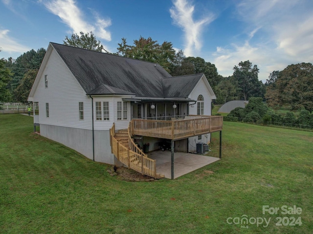 rear view of house featuring a yard, central AC, a wooden deck, and a patio area