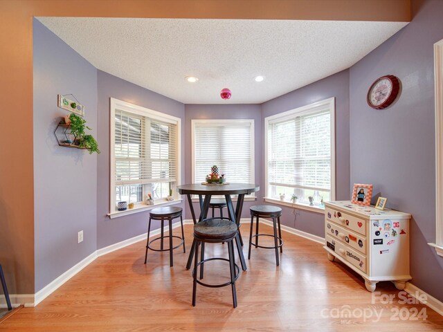 dining area featuring a textured ceiling and light hardwood / wood-style flooring