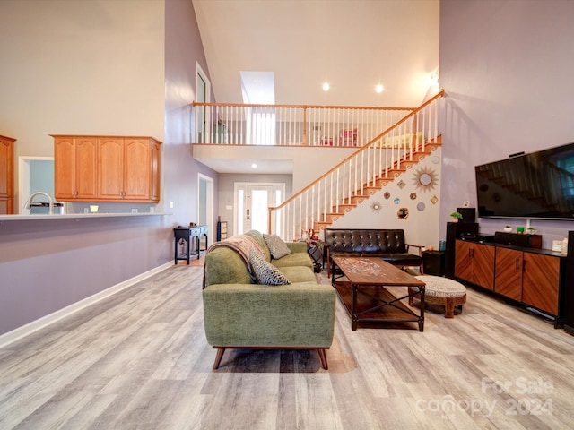 living room featuring light hardwood / wood-style floors and a high ceiling