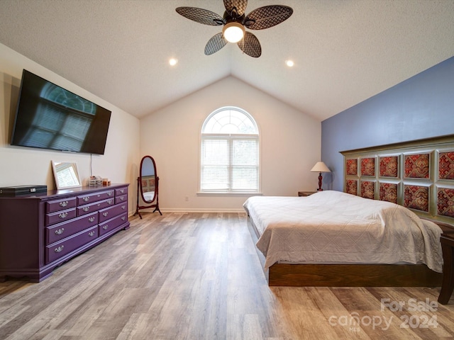 bedroom with ceiling fan, lofted ceiling, and light hardwood / wood-style floors