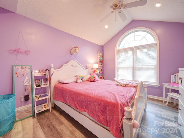 bedroom featuring wood-type flooring, lofted ceiling, ceiling fan, and multiple windows