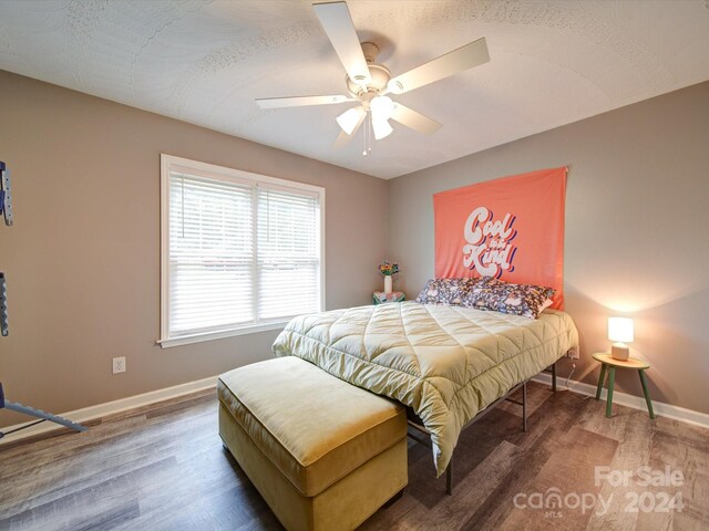 bedroom with a textured ceiling, dark hardwood / wood-style flooring, and ceiling fan