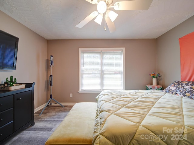 bedroom with a textured ceiling, dark hardwood / wood-style flooring, and ceiling fan