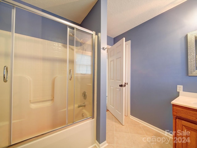 bathroom with bath / shower combo with glass door, vanity, tile patterned flooring, and a textured ceiling