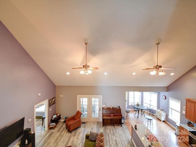 living room with high vaulted ceiling, light hardwood / wood-style floors, and ceiling fan