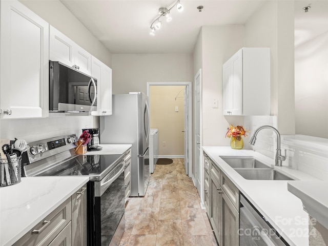 kitchen featuring light stone counters, sink, white cabinets, backsplash, and appliances with stainless steel finishes