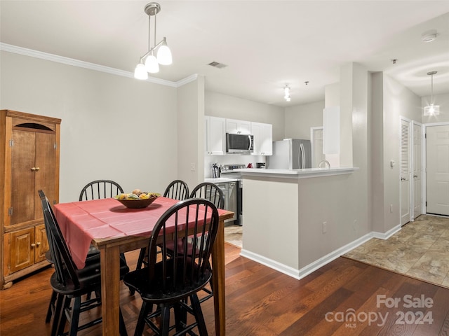 dining room featuring a notable chandelier, dark wood-type flooring, and crown molding