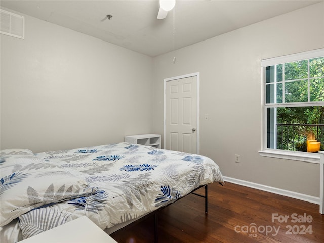 bedroom with multiple windows, dark hardwood / wood-style floors, and ceiling fan