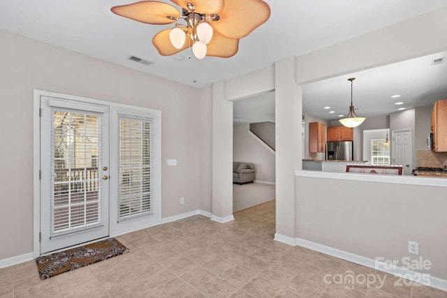 interior space featuring french doors, decorative light fixtures, stainless steel fridge with ice dispenser, ceiling fan, and backsplash