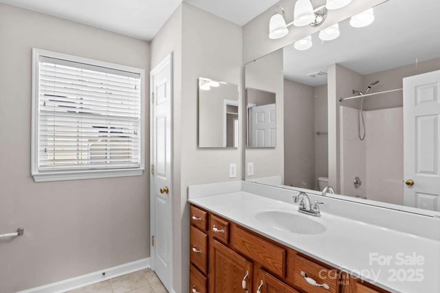 bathroom with tile patterned floors, plenty of natural light, toilet, and vanity