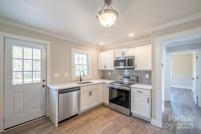 kitchen featuring white cabinetry, decorative backsplash, light hardwood / wood-style floors, and appliances with stainless steel finishes