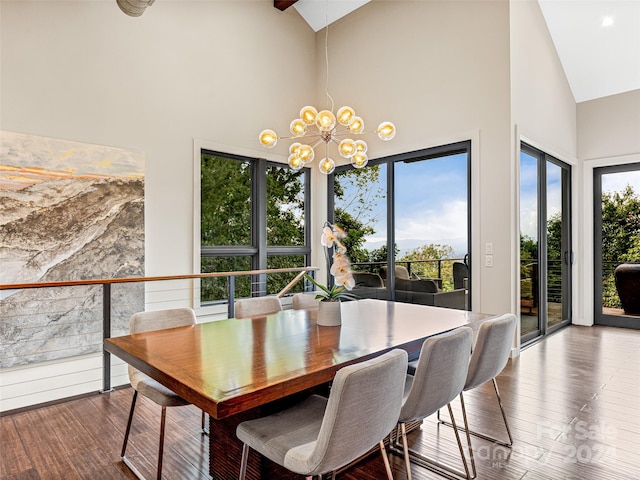 dining area with a chandelier, hardwood / wood-style floors, high vaulted ceiling, and a wealth of natural light