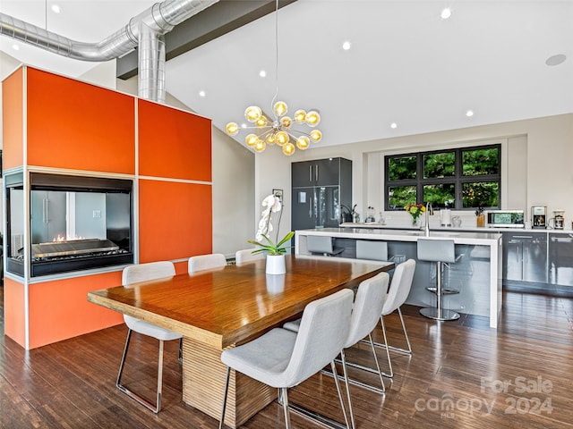 dining space featuring high vaulted ceiling, an inviting chandelier, and dark wood-type flooring