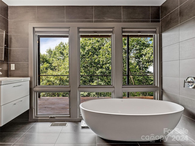 219 Old Toll Rd, Asheville, NC 28804 - bathroom with visible vents, a freestanding tub, vanity, and tile walls