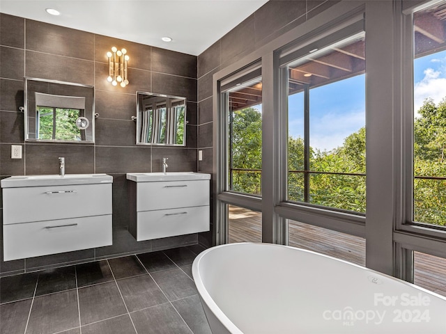 bathroom featuring vanity, tile walls, tile patterned flooring, and a bath