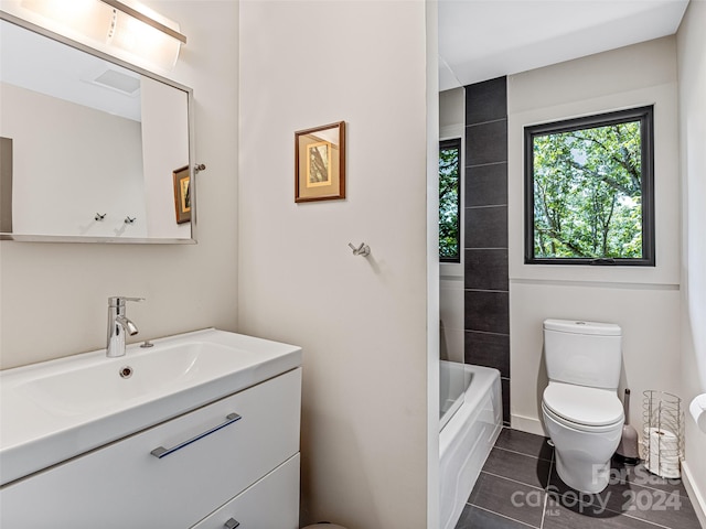 full bathroom with tiled shower / bath, vanity, toilet, and tile patterned floors